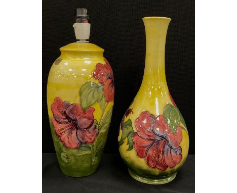 A Moorcroft pottery Hibiscus pattern lamp base, yellow ground, 27cm high, similar taller baluster vase, 32cm high (2) 