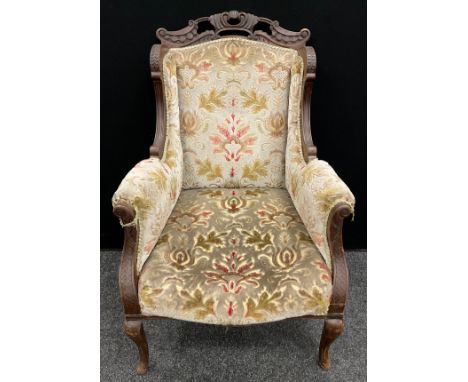 A Victorian carved walnut ‘Chinoiserie’ style wing-back armchair, carved top rail, scroll arms, cabriole legs, 97cm high x 65