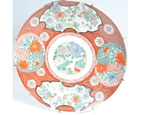 A large 19th Century Japanese Meiji period Arita ware charger of circular form decorated in the Imari pattern with red ground