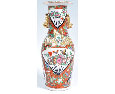 A 19th Chinese red coral ground vase having white enamel fan shaped panels with famille rose decoration depicting floral spra