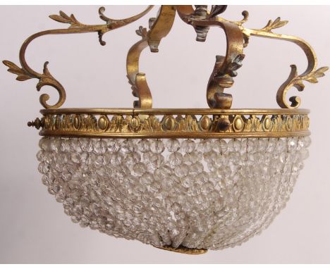 An early 20th Century Empire glass and brass basket chandelier ceiling light lamp fixture having three bulb holders with stra