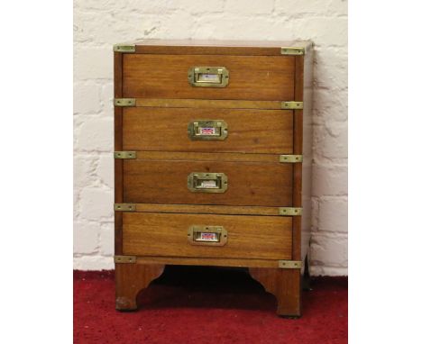 A small mahogany leather topped and brass bound four high chest of drawers raised on bracket feet.