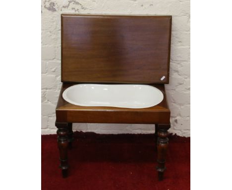 A Victorian mahogany babies bath and cover set with ceramic liner and raised on turned supports.