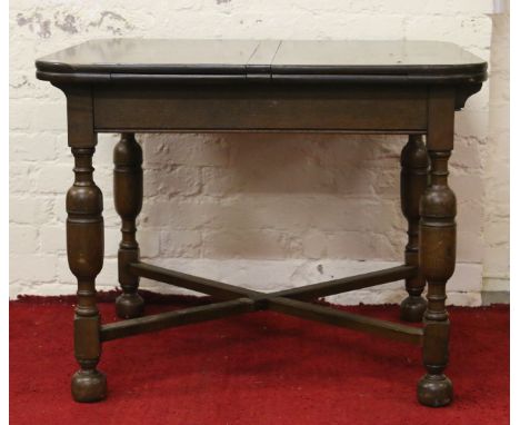 An oak drawleaf dining table raised on turned bulbous supports.