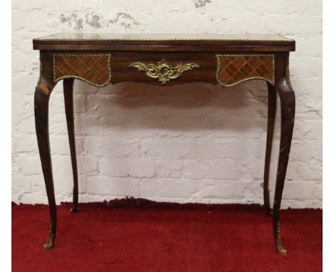 A 20th century parquetry inlaid fold over card table raised on cabriole supports.