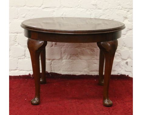 A circular mahogany coffee table raised on cabriole supports.