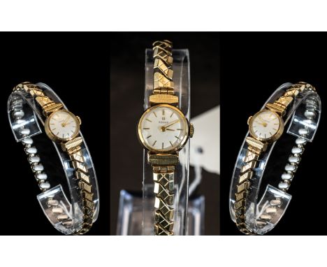 Ladies 9ct Gold Tissot Wrist Watch, white dial, Roman numerals, manual wind, on an expanding bracelet.