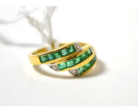 An emerald and diamond three row ring, set with calibré cut emeralds in yellow channel settings, with each row terminating wi