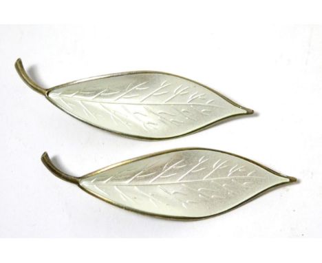 A pair of David Andersen white enamel and silver leaf form brooches 