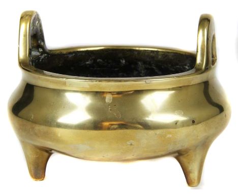 A Chinese bronze tripod censer, circular with high loop handles, and on tripod feet, Xuande six character mark to base, inter
