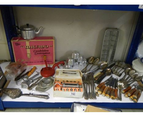 A shelf of assorted cutlery and other kitchen utensils.