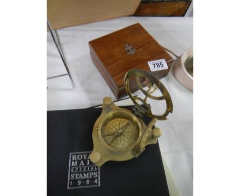 A brass compass in a wooden case. Needle is lockable & moves freely