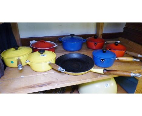 LE CREUSET. Shelf of Le Creuset cookware including pans and casserole