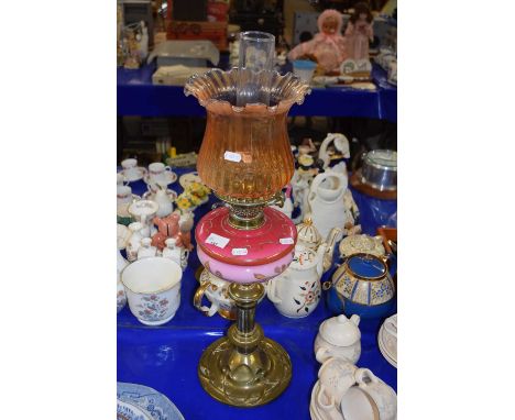 An Art Nouveau brass based oil lamp with opaque glass font and tinted shade