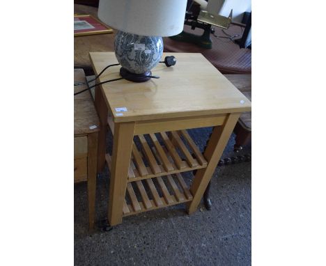 A modern light wood kitchen island cabinet on wheels