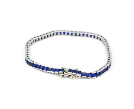 A 925 silver tennis bracelet set with square cut blue topaz, L. 20cm.