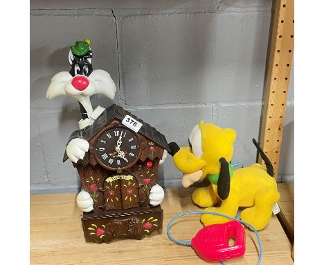 A Looney Tunes cuckoo clock together with a Pluto walking toy.