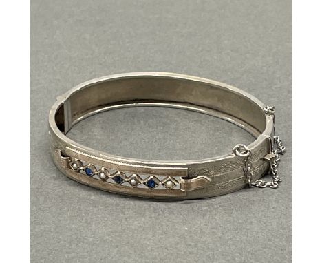 An Edwardian white metal (tested silver) stone set bangle.