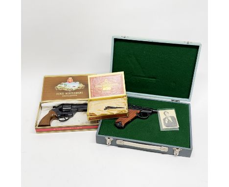 A cased toy Luger gun together with two others.