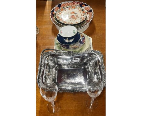 A silver plated basket with a quantity of mixed ceramic and glass items.