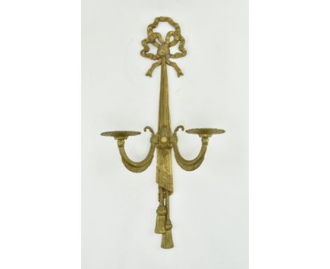 An early 20th century Regency revival gilt metal single wall sconce. Each sconce featuring tied ribbon motif over rope tie co