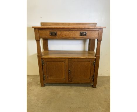 An arts and crafts style early 20th century light oak side board with copper and brass fittings with bevelled gallery to top 