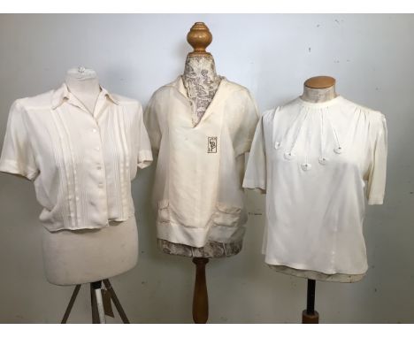 Three blouses. A cream silk short sleeved blouse with patch pockets, circa 1920s, a cream short sleeved blouse with open work