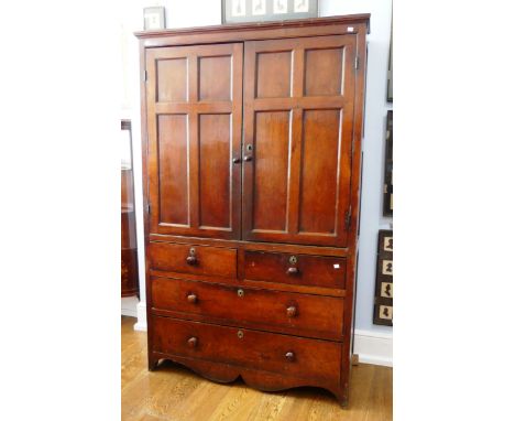 An early 19th century elm Cupboard, the moulded cornice above a pair of paneled doors enclosing shelves, two short drawers an