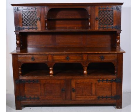 Oak sideboard, raised back with an open arch incorporating a shelf, flanked by fret panelled doors, backed by glass, base sec