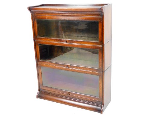 An early 20thC oak Globe Wernicke type bookcase, in three sections with hinged glass doors on a shaped base, 113cm H, 86cm W,