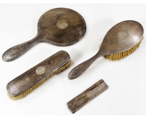 A George V silver dressing table set, comprising hand mirror, 28cm W, clothes brush, hair brush and comb, London 1913, the co