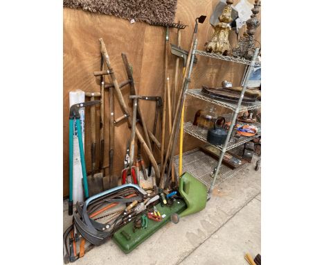 A LARGE ASSORTMENT OF GARDEN TOOLS TO INCLUDE A SYTHE, SPADES, FORKS AND BOW SAWS ETC 