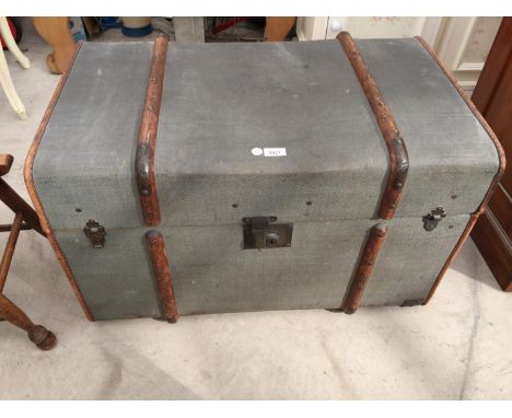 AN OAK BOUND TRAVEL TRUNK WITH LEATHER HANDLES AND INNER SHELF 