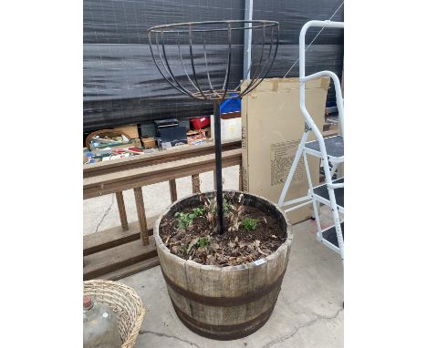 AN OAK HALF BARRELL PLANTER WITH METAL PLANTING BASKET 