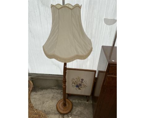 A WALNUT STANDARD LAMP AND AN OAK FRAMED TAPESTRY FIRE SCREEN 