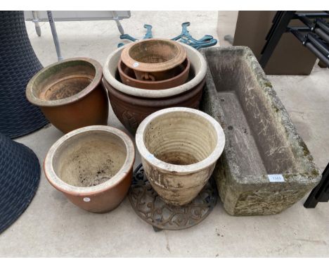 A RECONSTITUTED STONE TROUGH AND AN ASSORTMENT OF GLAZED POTS 