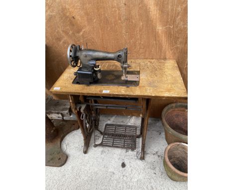 A VINTAGE SINGER SEWING MACHINE WITH CAST TREADLE BASE 