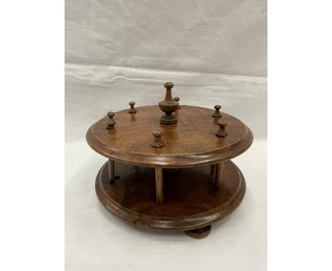 A 19TH CENTURY WALNUT BOBBIN HOLDER ON THREE FEET WITH A TURNED FINIALE TO HOLD SIX BOBBINS 