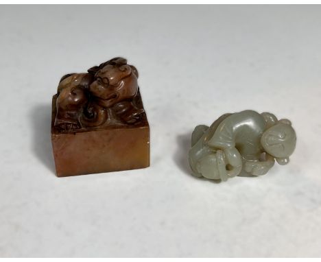 A Chinese jade coloured hardstone carving of a figure with a basket, and a hardstone seal. 