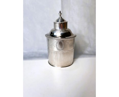 An oval white metal tea caddy with chased decoration, beaded rim and flared lower section marked for "leitão e irmão" Portuga