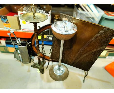 An Art Deco pedestal ashtray in chrome; a brass pedestal ashtray; a metal companion set and firescreen; an oval wall mirror i