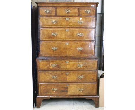 A George I walnut tallboy chest, c.1725, feather banded, the cavetto cornice above three long drawers within fluted canted co