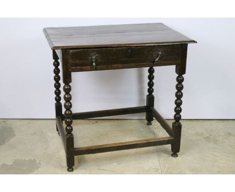 18th Century oak side table having twin drop handles to single drawer and bobbin turned legs united by stretchers. Measures 7