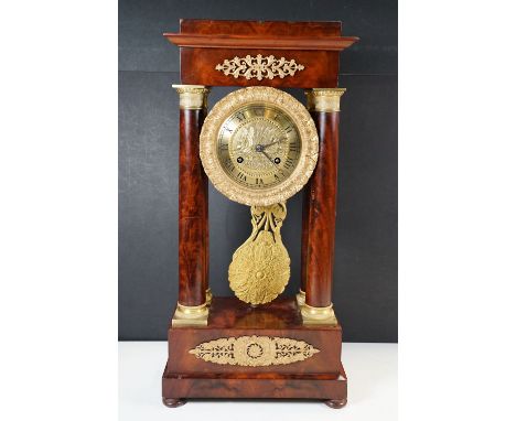 An Empire mahogany and ormolu mounted mantel clock of classical form, the circular dial flanked by columns, the unsigned move