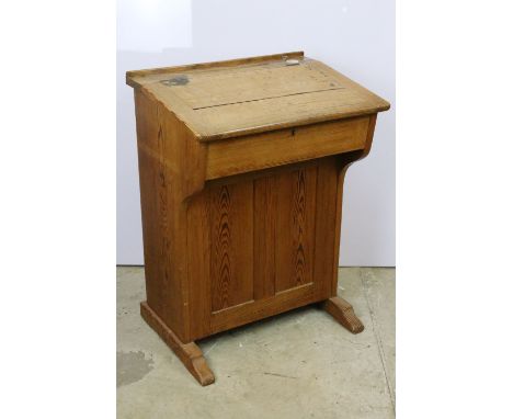 Early 20th century pine school desk, with cream ceramic inkwell, the lid lifts to reveal storage, hinged door to back opening