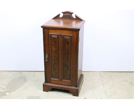 Early 20th century mahogany bedside cabinet with carved pediment abov single panelled door, raised on bracket feet, 85.5cm hi