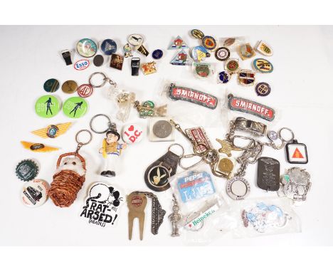 A collection of souvenir and advertising button badges, enamel badges and keyrings.