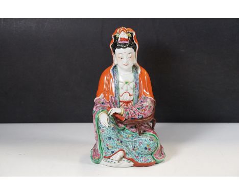 A Chinese ceramic hand painted statuette depicting a seated Guan Yin, with a stamped character marks to base, H 27cm