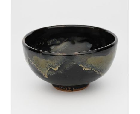 Jim Malone (born 1946) a stoneware, footed bowl, covered to the foot with a tenmoku glaze and copper pours, impressed marks, 