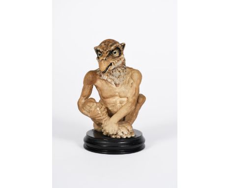 A rare Martin Brothers stoneware Birdman jar and cover by Robert Wallace Martin, modelled seated and holding his leg,  glazed